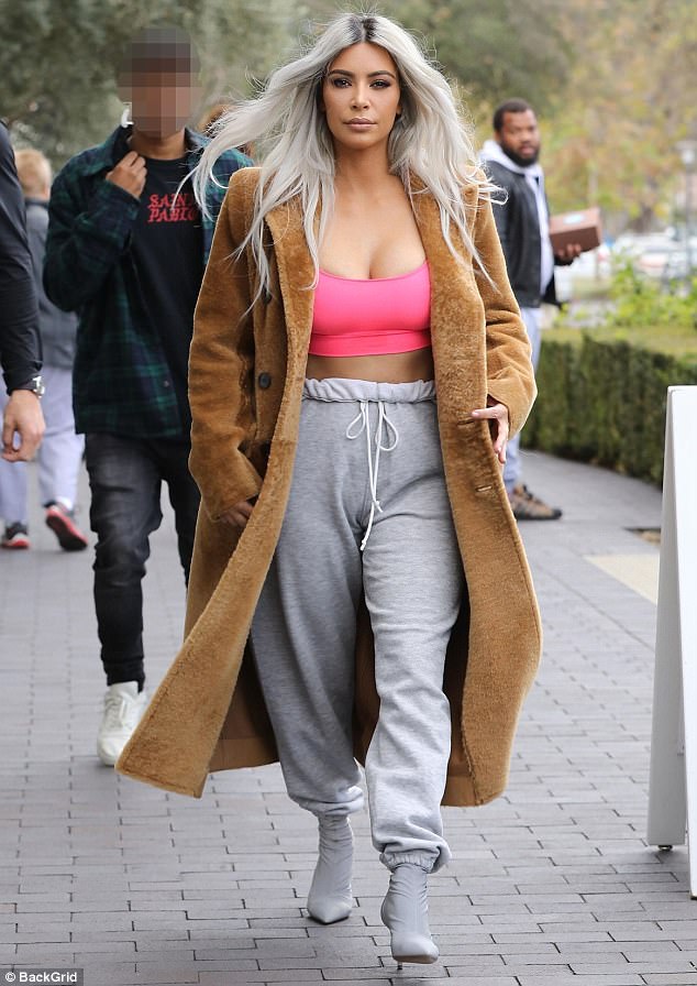 Kim Kardashian looks Valentine’s Day ready in bright crop top with sweats and a camel coat while heading to flower shop